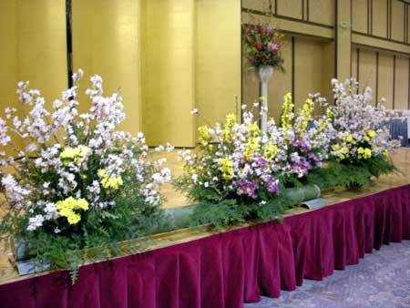 竹を器にして枝物（桜）でホテルの会場を飾るアレンジメント